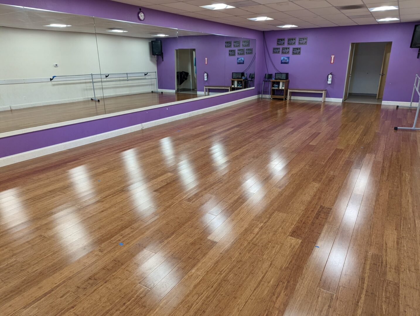 A dance studio with purple walls and wooden floors.