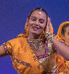 A woman in an orange sari is smiling.